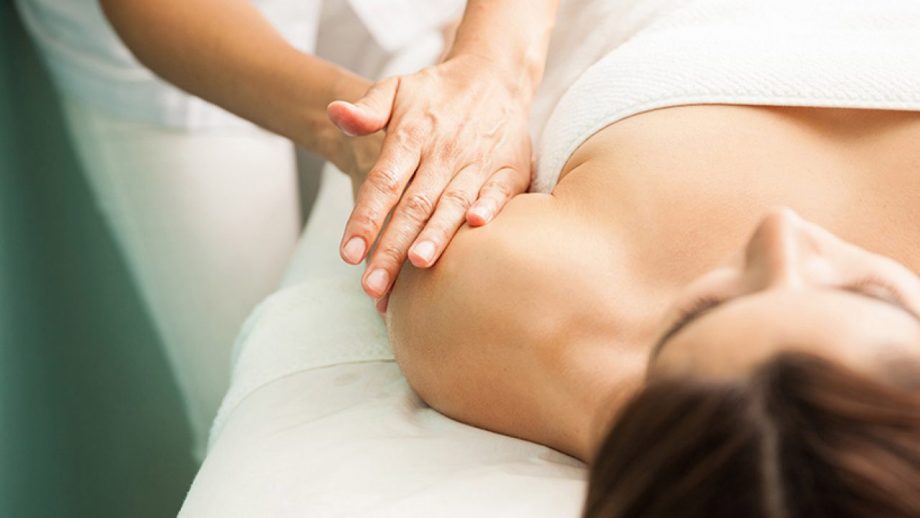 Frau wird massiert durch Masseur