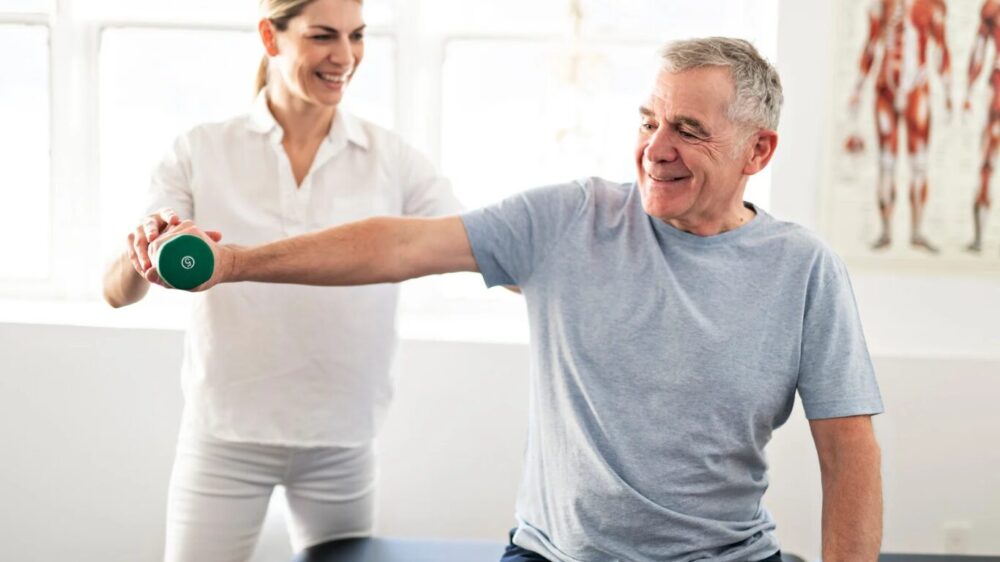 Patient männlich macht Übung mit Therapeutin